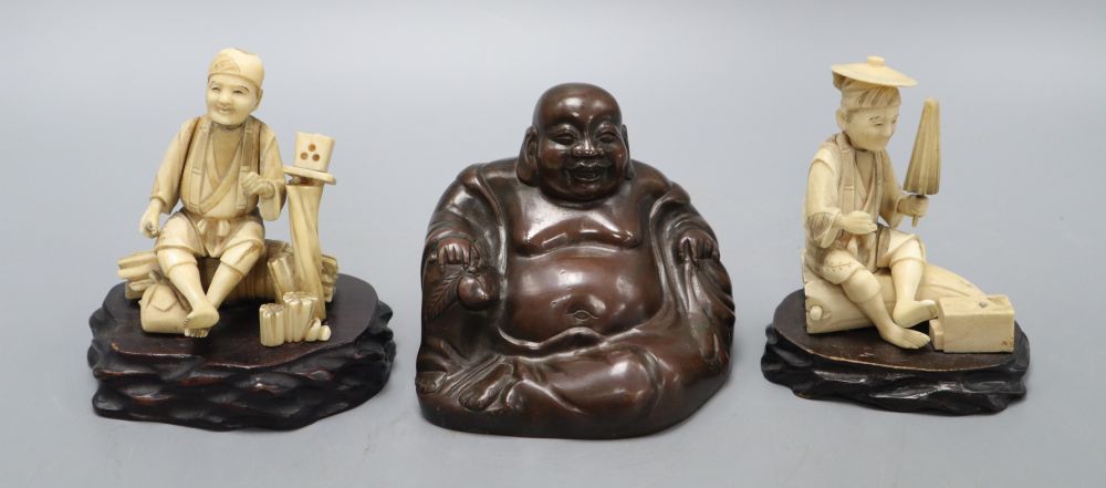 A Chinese bronze figure of a Budai and two Japanese carved ivory figures on stand